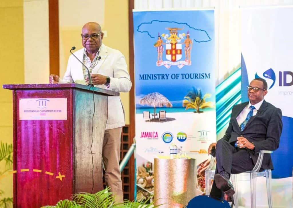 Ministro de Turismo Excmo Edmund Bartlett pronuncia el discurso de apertura en un Taller de Desarrollo de Estrategias del Ministerio de Turismo en el Centro de Convenciones de Montego Bay St James Mirando sentado está el Director General de Servicios Técnicos Ministerio de Turismo David Dobson Jamaica