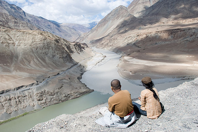 Locals relax at the confluence of the Zanskar (middle) and Indus (left) rivers. Photo by Ridhi D'Cruz via Wikimedia Commons.